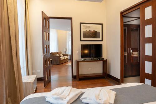a hotel room with a bed and a television at Parc Royale Suites Hotel in Cuenca