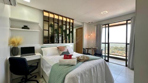 a bedroom with a bed with a desk and a laptop at (1406) Elegant Studio with Sea View in Vinhais