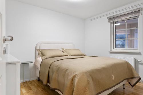 a white bedroom with a bed and a window at Villa i Sollentuna - Lyx, Komfort och Privat Gym in Sollentuna