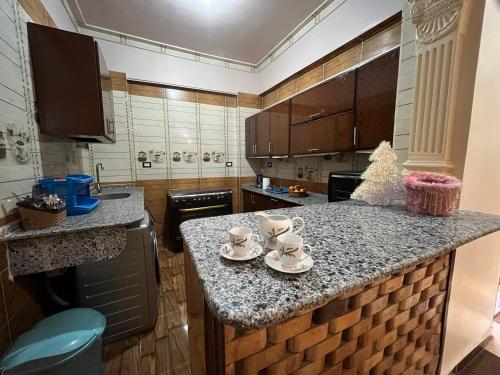 een keuken met een aanrecht met kopjes en schotels erop bij Habiba Apartment in Luxor
