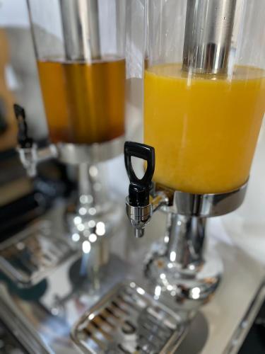 two glasses of orange juice sitting on top of a juicer at Villa Aruba & Private SPA Suites in Keszthely