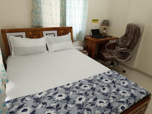 a bedroom with a bed and a desk and a chair at 2BHK AC Service Apartment 204 Bhugaon in Pune