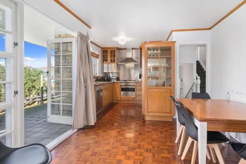a kitchen with a wooden table and a dining room at Thermal Adventure Retreat in Rotorua