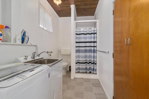a white kitchen with a sink and a toilet at Thermal Adventure Retreat in Rotorua