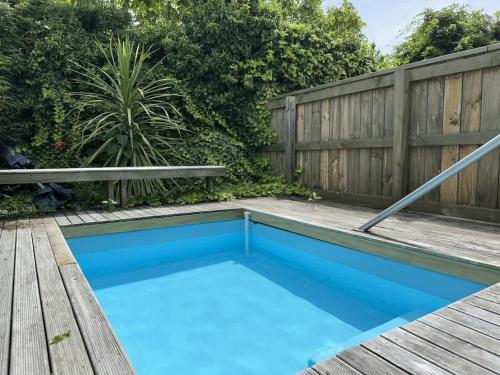 a swimming pool in a backyard with a wooden fence at Thermal Adventure Retreat in Rotorua