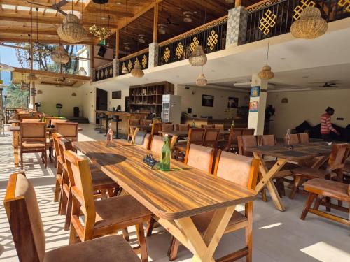 a dining room with wooden tables and chairs at Nature's Nest Resort in Rongli
