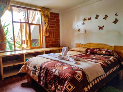 a bedroom with a bed and a window at Hostal Cloud Forest in Chugchilán
