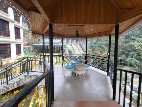 a balcony of a house with a table and chairs at Nature's Nest Resort in Rongli