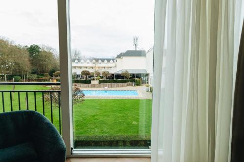 a window with a view of a yard at Hotel de Zeeuwse Stromen - Duinpark in Renesse