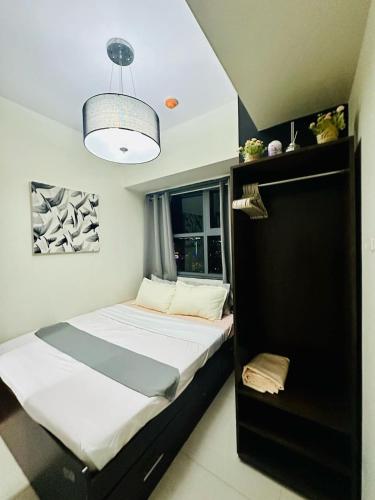 セブシティにある31T1 Chic Corner, Horizons 101, Cebu Cityの小さなベッドルーム(ベッド1台、照明付)