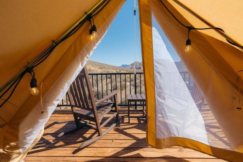 a view from the inside of a tent with a chair on a deck at Zion Wildflower Resort in Virgin