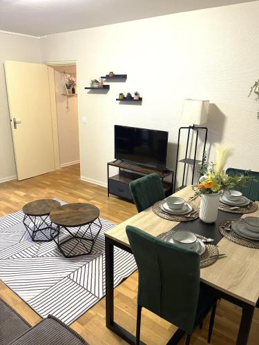 un salon avec une table et une télévision dans l'établissement Charmant Appartement à Metz, à Metz