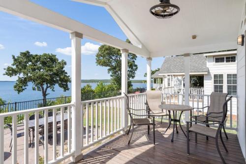 a porch with chairs and a table with a view of the ocean at CrossTimbers Marina and Cottages in Sperry