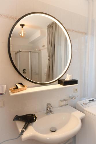 a white bathroom with a sink and a mirror at Hotel Goldene Rose in Monguelfo