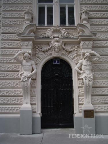 a building with two statues in front of a door at Pension Riedl in Vienna