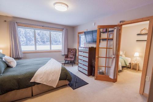 a bedroom with a bed and a dresser and a mirror at Bear Lake Lodgings B&B, Inc in Seward