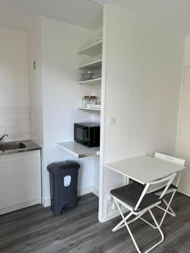 une petite cuisine avec une table blanche et un four micro-ondes dans l'établissement Studio Surcouf, à Rennes