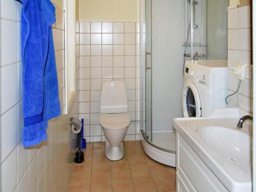 a bathroom with a toilet and a sink and a washing machine at 7 person holiday home in VANKIVA-By Traum in Vankiva