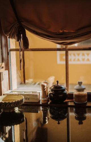 a table with a bed and a pot and a book at Joyard - Pensiune & Parc in Porumbacu de Sus