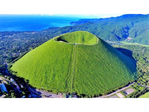 a large green hill with the ocean in the background at Le Nessa Akazawa - Vacation STAY 03714v in Futo