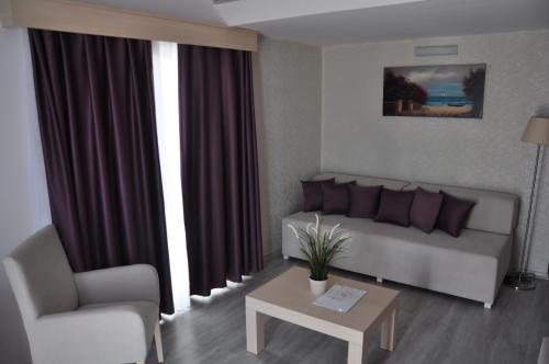 a living room with a couch and a chair at Manolya Hotel in Kérynia