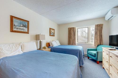 a hotel room with two beds and a television at 204 at Rivergreen in Lincoln
