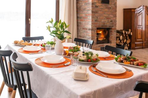 a table with a white table cloth with food on it at Agroturystyka Świętego Józefa in Chrzypsko Wielkie