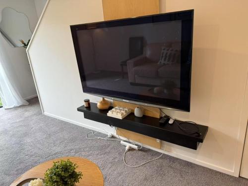 a flat screen tv on a wall in a living room at A Quiet Modern and Brand New Gem in Lower Hutt