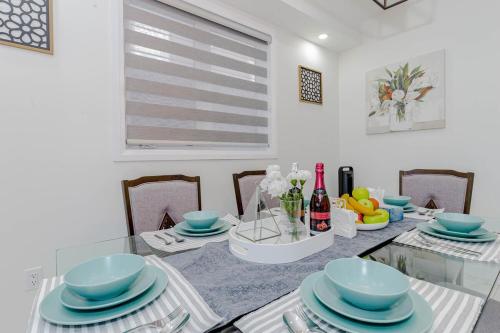a dining room with a glass table with blue dishes at Amazing Home in Niagra Region in Thorold