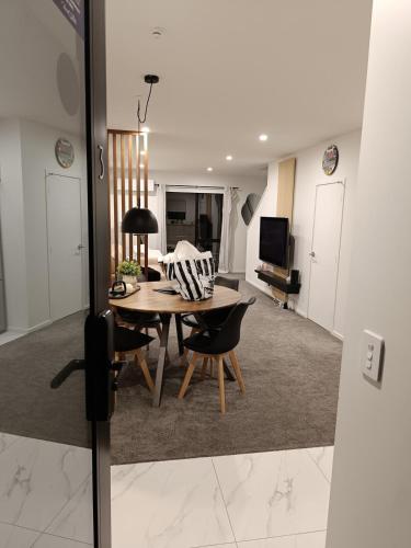 a living room with a table and chairs and a couch at A Quiet Modern and Brand New Gem in Lower Hutt