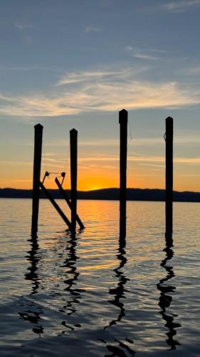 a group of poles in the water at sunset at Modern Waterfront Home in Lucerne in Lucerne