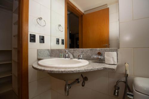 un baño con lavabo y espejo en OZPED Flats Particulares Edifício Biarritz, en Brasilia