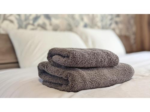 une pile de serviettes posée sur un lit dans l'établissement Yonagunijima Hotel Munbu Stay Kukomae - Vacation STAY 93739v, à Sonai