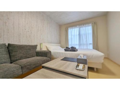 a living room with a couch and a bed at Yonagunijima Hotel Munbu Stay Kukomae - Vacation STAY 03880v in Sonai