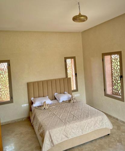 two stuffed animals sitting on a bed in a bedroom at Villa Bellevue Marrakech in Sbiti