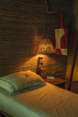 a bedroom with a bed and a lamp on a table at Isla Fuerte Eco House in Isla Fuerte