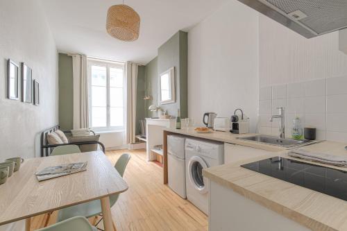 une cuisine avec lave-linge, sèche-linge et une table dans l'établissement LYON - Charmant T2 Gare Part-Dieu, à Lyon