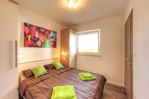 een slaapkamer met een bed met twee groene handdoeken erop bij Apartments Nebuloza in Rovinj