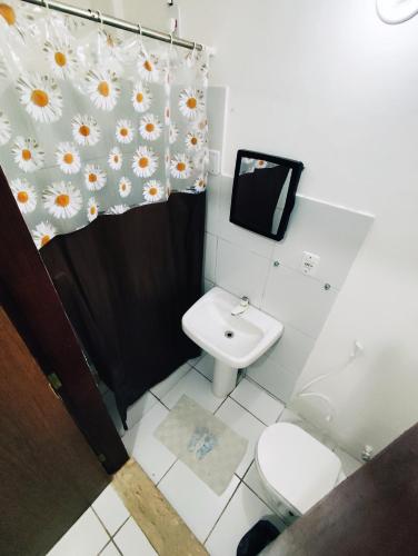 a bathroom with a toilet and a shower curtain at Ponta Negra Suites & Apart in Natal