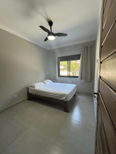 a bedroom with a bed and a ceiling fan at Condomínio Apoena in São Sebastião