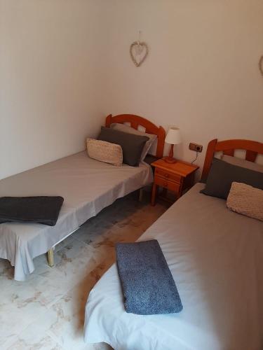 a room with two beds and a table with a lamp at Pinada Golf Apartment in Orihuela Costa