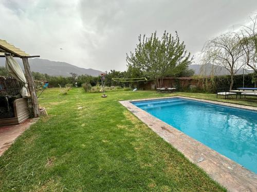 a swimming pool in a yard with a grass field at Ferme Tibrijine in Marrakech