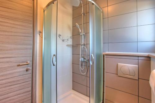 羅維尼的住宿－Apartments Nebuloza，浴室里设有玻璃门淋浴