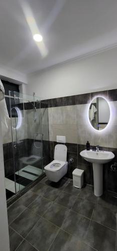 a bathroom with a toilet and a sink and a shower at Hotel kleo Airport tirana in Tirana