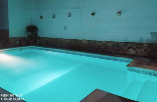 a swimming pool with blue lighting in a house at Villa La Luna CHALET COMPLETO in Guadajira