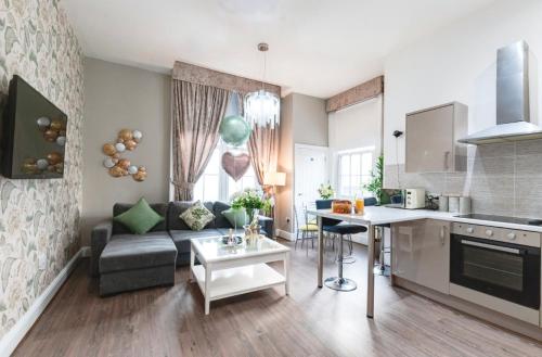 a kitchen and living room with a couch and a table at Elysium Liverpool in Liverpool
