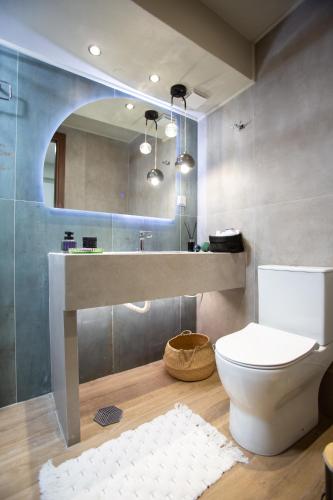 a bathroom with a toilet and a sink and a mirror at Liberty Suites II in Heraklio