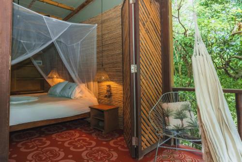 a bedroom with a bed and a chair in a room at Isla Fuerte Eco House in Isla Fuerte