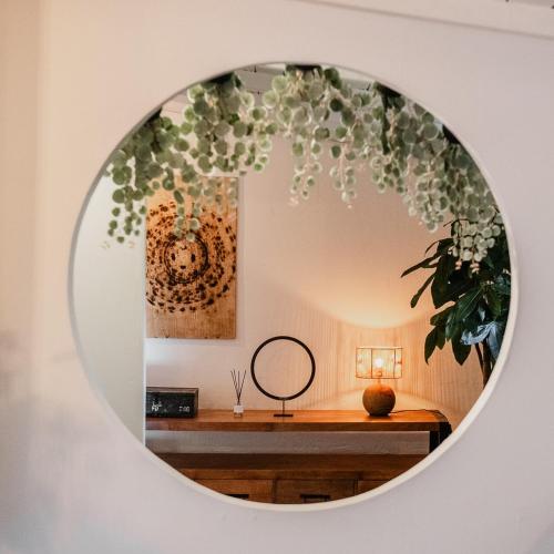 a mirror on a wall with a table with a mirror at Planty - studio with bath tub in Halle