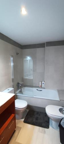 a bathroom with a tub and a toilet and a sink at Apartamento Elegance Benidorm in Villajoyosa